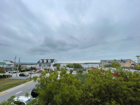 Charming waterfront community with coastal homes dotting the scenic shoreline under dramatic cloudy skies.