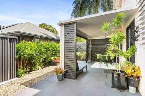 Outdoor patio area with dining table, sunlounger and tool shed. 