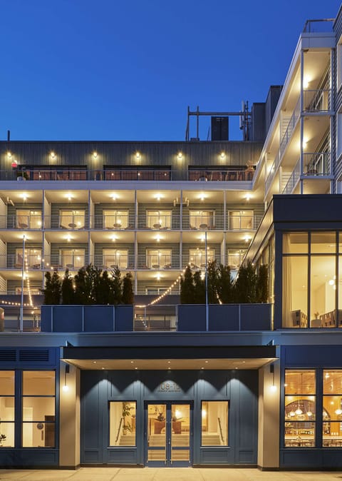 Evening view with lit balconies, string lights, and layered terraces