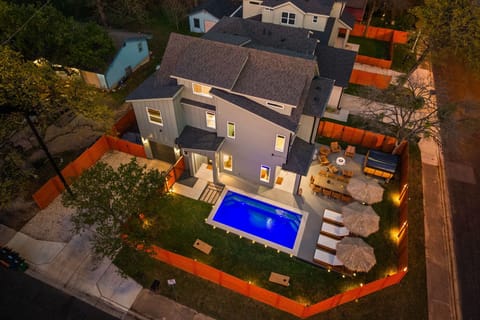 Aerial view of the property showcasing the pool, lounge areas, and outdoor space