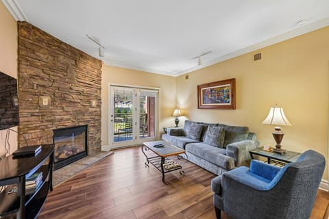 Unwind in your cozy living room with stone fireplace and plush seating, perfect for relaxing evenings.