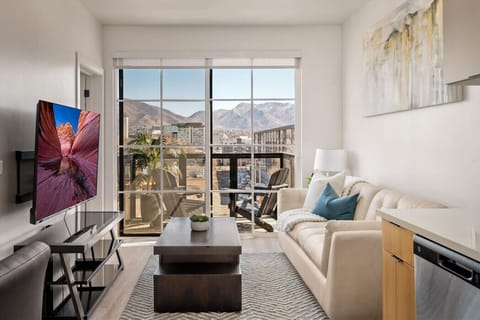 Beautifully designed living room. 60` TV, leather sofa and amazing views of mountains and city skyline.