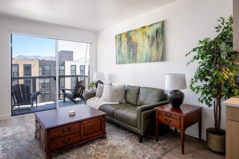 Beautifully designed living room. 60` TV, leather sofa and amazing views of mountains and city skyline