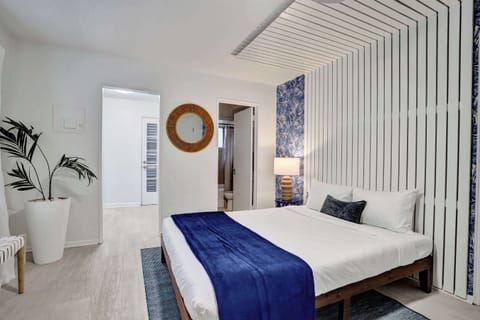 Queen bed with tropical wallpaper accent and closet