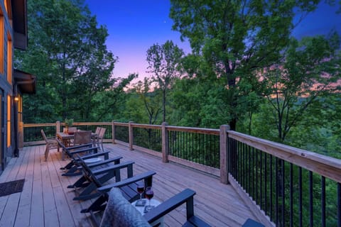 Unwind on the expansive deck with sunset views, cozy lounge seating, and peaceful treetop surroundings.