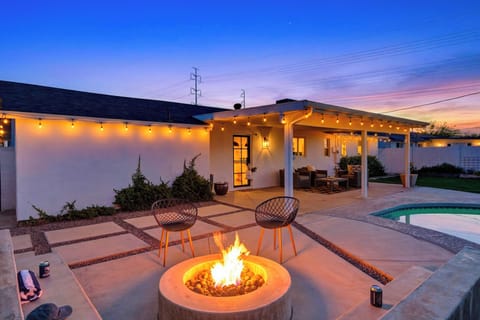 Full view of the backyard patio and firepit under the twilight sky.