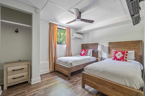 A bright twin bedroom in Asheville offering modern comforts, perfect for travelers seeking a convenient and relaxing stay. This unit is located on the ground floor for easy access.