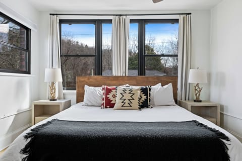 Bright king bedroom featuring cozy linens, warm décor, and a relaxing atmosphere.