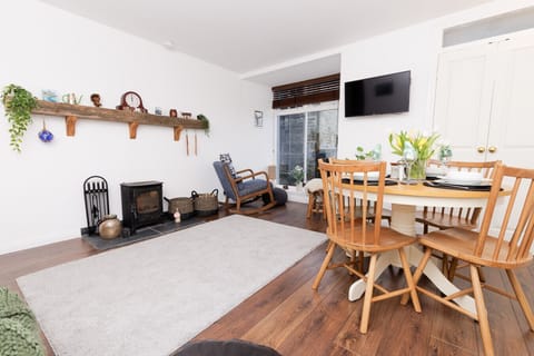 Living and dining area with log burner and wall-mounted TV
