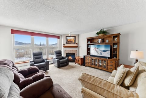 Relax in your spacious living room with mountain views, cozy fireplace, and entertainment center for perfect mountain retreat evenings.