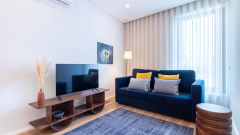 Cozy living room with a comfortable blue sofa and stylish décor. The soft light and artwork create a welcoming atmosphere. #Relaxation #ModernLiving