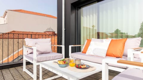 A cozy and inviting terrace with comfortable seating, perfect for enjoying a peaceful breakfast or relaxing in the sun. The orange accents add a vibrant touch. #TerraceVibes #OutdoorLiving
