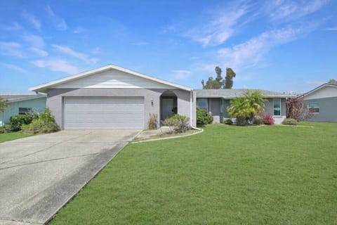Charming suburban home with a spacious driveway and lush front yard.