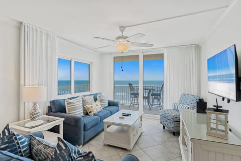 Your beachfront living room offers stunning ocean views through floor-to-ceiling windows, with cozy seating and your private balcony just steps away.