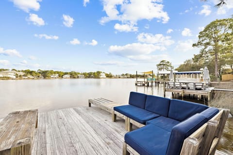 Serene waterfront setting with comfortable seating overlooking calm waters and charming coastal homes.