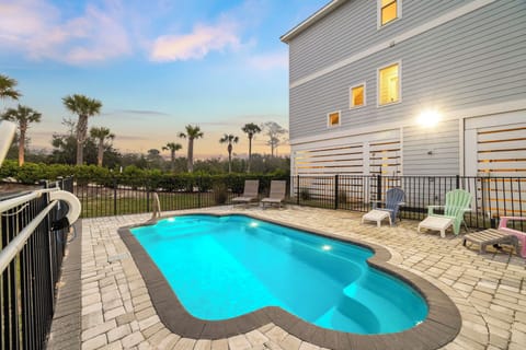 Your private oasis awaits with a sparkling pool surrounded by tropical palms and comfortable lounging areas for ultimate relaxation.
