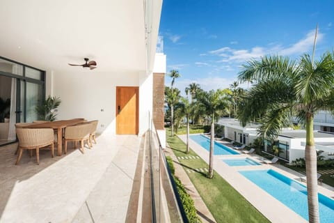 Spacious balcony with dining area—perfect for meals or coffee while overlooking the pool and palm-lined grounds.