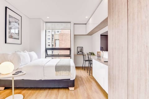 Bright open-concept space combining bedroom and kitchen with modern finishes.