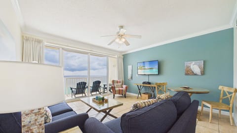 Open concept living area has sleeper sofa and TV with balcony access (sleeps 2)