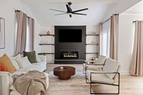 Living Room – Fireplace Feature Wall
Modern lounge with statement fireplace, mounted TV, and stylish open shelving.