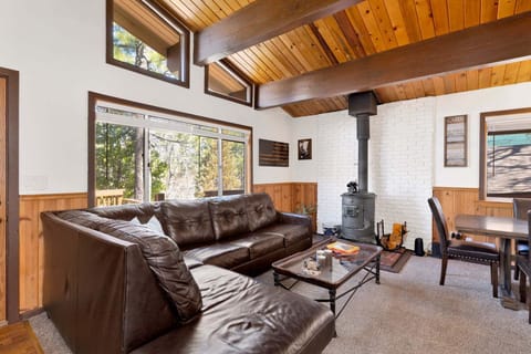 Cozy mountain living room with a fireplace, comfy seating, and smart TV—perfect for relaxing evenings, movie nights, and warm cabin vibes after outdoor adventures.