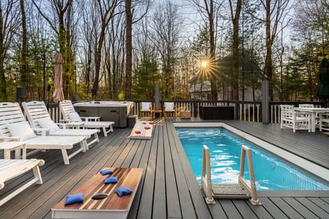 Private outdoor plunge pool set on a spacious deck with lounge seating and wooded views. Perfect for cooling off, relaxing in the sun, or enjoying time together in a peaceful setting.