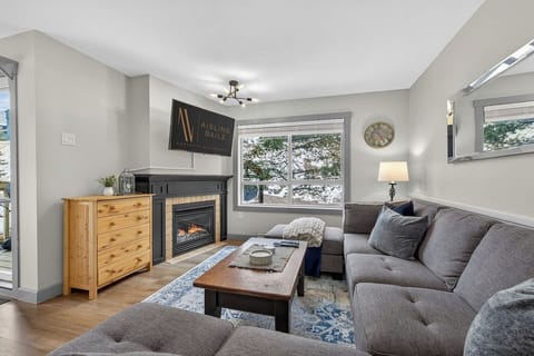 Living room with a gas-lit fireplace, a 42` Smart/ROKU TV with cable and a cozy sectional.