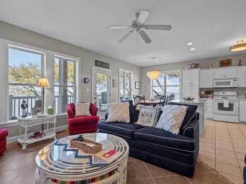 Unwind in your bright, coastal-themed living space where nautical decor and lake views create the perfect beach house atmosphere for relaxation.