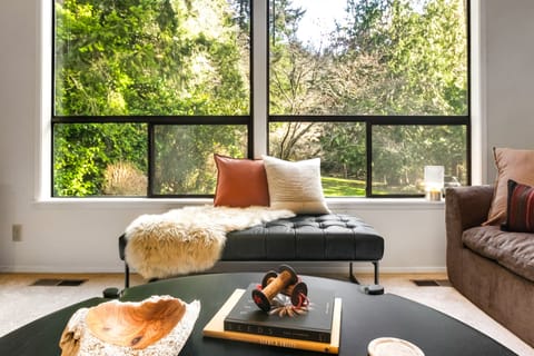 A large round coffee table in the living room is the perfect stage for your charcuterie and cheese plate. Play games or share snacks while enjoying the forest view.