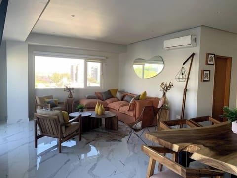 Sala de estar con bonita decoración, aire acondicionado y TV de 65"