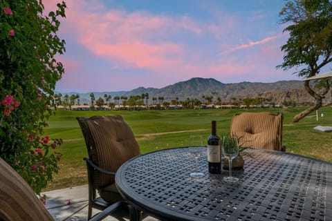 Sip wine at the patio table as sunset colors stretch over the open green landscape
