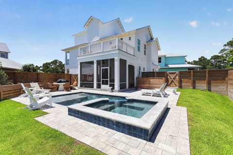 Modern backyard oasis with a sleek pool, raised spa, and plenty of loungers for sun‑soaked 30A days.