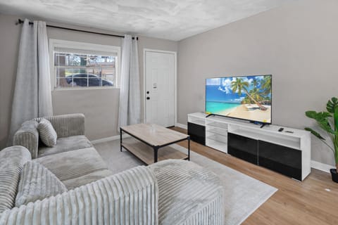 Bright and cozy living room with comfortable seating and a smart TV.