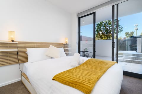Wake up refreshed in the light-filled bedroom with soft linens and direct balcony access.