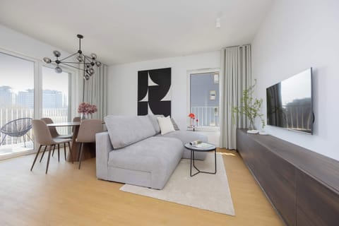 Modern living room with sofa, TV wall and wooden flooring