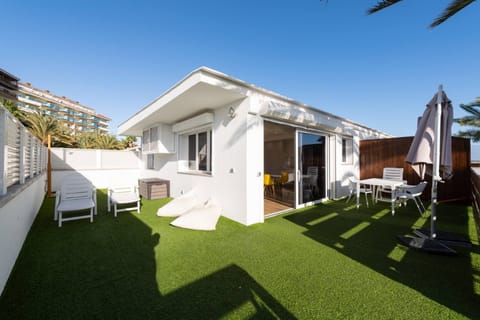 Private 50 m² terrace with artificial grass, table with chairs and umbrella, perfect space for dining and enjoying the sun