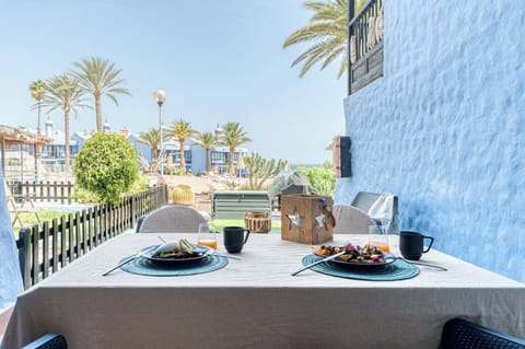 Private terrace with table, chairs, barbecue, and artificial grass, with views of the sunbathing area and communal pool