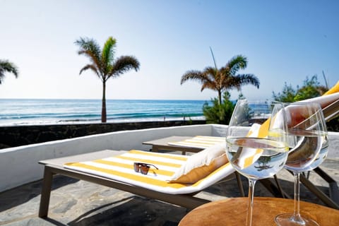 Sunny terrace with sea views, equipped with parasols, the perfect spot to enjoy a drink by the ocean.