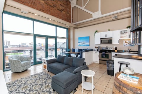 Relax in this bright loft with soaring ceilings, exposed brick walls, and a fully equipped kitchen opening to your cozy living space.