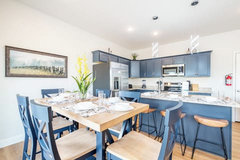 Your open-concept kitchen flows seamlessly with dining space, featuring sleek blue cabinetry and granite countertops perfect for cooking and gathering together.