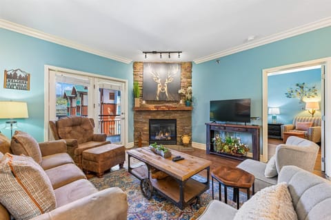 Cozy up in your spacious living room featuring a stone fireplace, plush seating, and rustic charm that makes every evening feel like home.