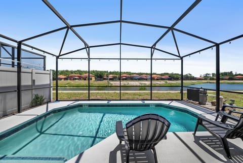 Step outside to a refreshing pool area surrounded by a sleek screen enclosure, offering a clear view of the serene water beyond. The inviting lounge chairs beckon you to relax and soak up the sun in style.