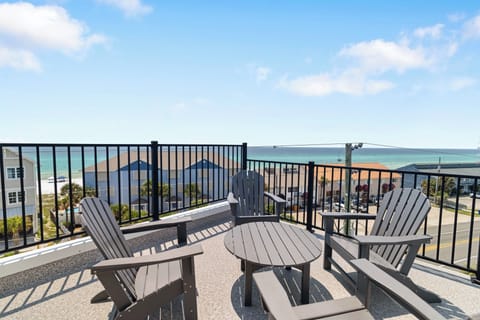 A comfortable seating arrangement overlooks stunning turquoise waters stretching to the horizon, perfect for your morning coffee or evening relaxation under open skies.