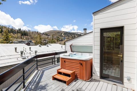 Private outdoor deck with hot tub, perfect for unwinding while enjoying fresh mountain air and scenic views.