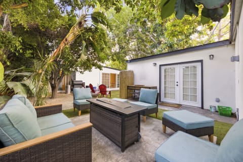 Relaxing outdoor patio with comfortable seating, surrounded by greenery—ideal for entertaining or unwinding.