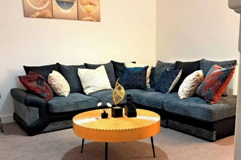Bright living room with lots of seating space, fire place and TV