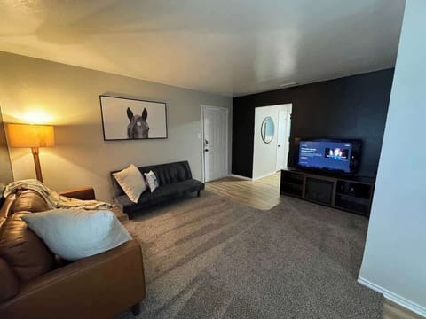 Living room with futon, leather couch, and 50" smart TV