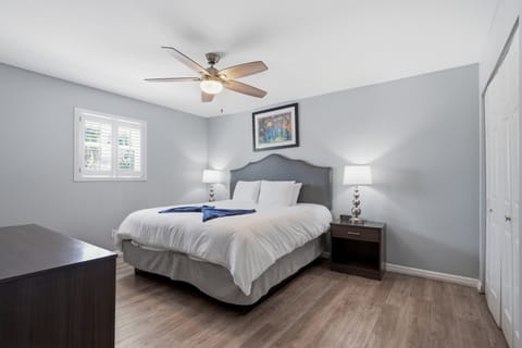 Serene primary bedroom w/ a plush bed & calm grey tones for restful nights.
