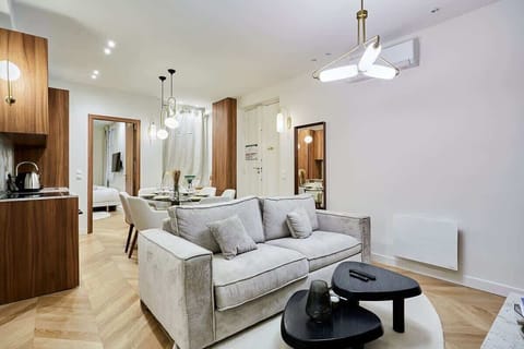 Belle pièce à vivre ouverte avec canapé, smart TV, table basse et espace repas.