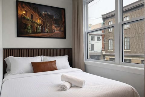Chambre Queen : Refuge lumineux et aéré doté d'un lit queen moelleux et d'une vue imprenable sur la rue !